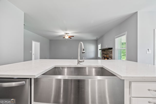 502 Wilbanks Rd, Alto, GA 30510 - kitchen with stainless steel dishwasher, a stone fireplace, open floor plan, a ceiling fan, and light stone countertops