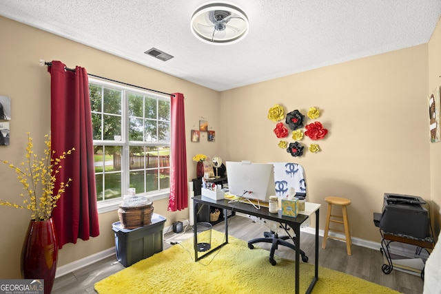 7030 Kingston Ln, Mcdonough, GA 30253 - home office with a textured ceiling and wood finished floors