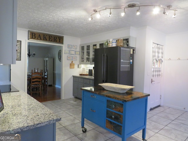 141 Cherokee Cir, Cedartown, GA 30125 - kitchen with black appliances, blue cabinetry, light tile patterned flooring, glass insert cabinets, and a textured ceiling