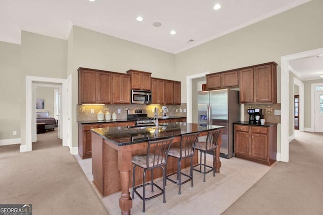 21 Creekview Dr SE, Cartersville, GA 30120 - kitchen featuring stainless steel appliances, light colored carpet, a kitchen breakfast bar, an island with sink, and backsplash