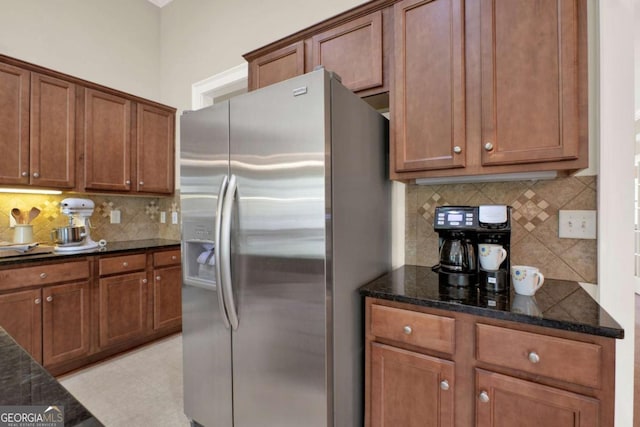 21 Creekview Dr SE, Cartersville, GA 30120 - kitchen featuring stainless steel fridge, backsplash, dark stone countertops, and brown cabinets