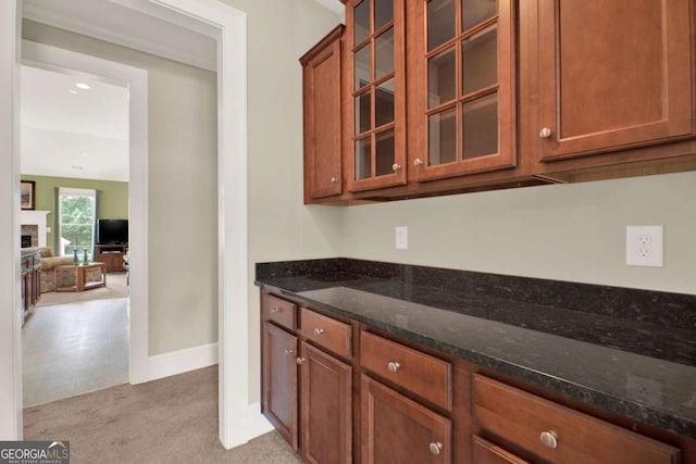 21 Creekview Dr SE, Cartersville, GA 30120 - kitchen featuring light carpet, dark stone counters, and brown cabinetry
