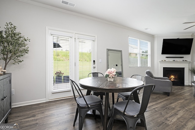 7814 Messina Ct, Lithia Springs, GA 30122 - dining room with ornamental molding, a warm lit fireplace, dark wood-style floors, and a ceiling fan