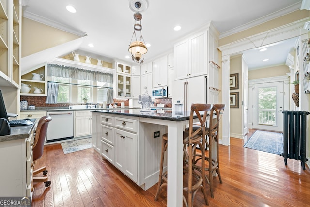 3349 Whitepath Rd, Ellijay, GA 30540 - kitchen featuring white appliances, crown molding, healthy amount of natural light, a breakfast bar, and hardwood / wood-style floors