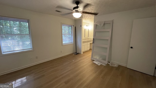 4710 Cedar Brook Dr SE, Conyers, GA 30094 - unfurnished bedroom featuring wood finished floors, a textured ceiling, ensuite bath, and ceiling fan