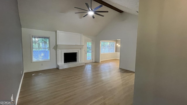 4710 Cedar Brook Dr SE, Conyers, GA 30094 - unfurnished living room with a ceiling fan, beamed ceiling, high vaulted ceiling, wood finished floors, and a fireplace