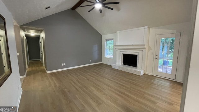 4710 Cedar Brook Dr SE, Conyers, GA 30094 - unfurnished living room with ceiling fan, wood finished floors, a fireplace, and attic access
