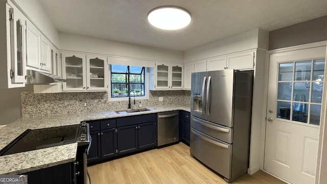 4710 Cedar Brook Dr SE, Conyers, GA 30094 - kitchen featuring stainless steel appliances, under cabinet range hood, light wood-style flooring, white cabinetry, and light stone countertops