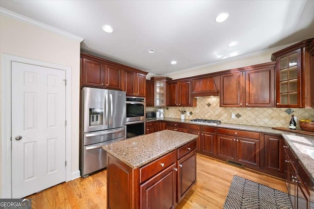 214 Davis Mill Rd, Ball Ground, GA 30107 - kitchen featuring appliances with stainless steel finishes, ornamental molding, light wood-style flooring, custom range hood, and light stone countertops