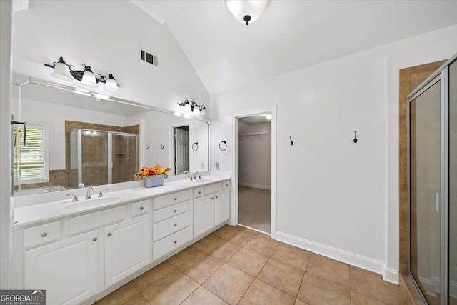 214 Davis Mill Rd, Ball Ground, GA 30107 - full bathroom with vaulted ceiling, a shower stall, double vanity, tile patterned flooring, and a walk in closet