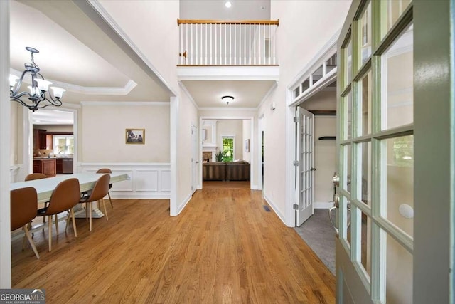 214 Davis Mill Rd, Ball Ground, GA 30107 - entrance foyer with plenty of natural light, a chandelier, ornamental molding, light wood finished floors, and wainscoting