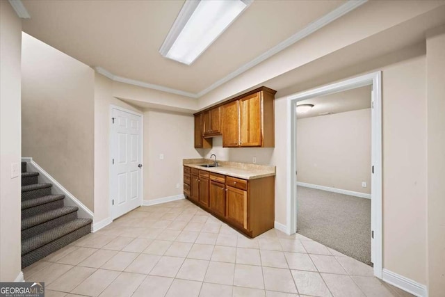 214 Davis Mill Rd, Ball Ground, GA 30107 - kitchen featuring light countertops, brown cabinetry, light tile patterned floors, crown molding, and light carpet