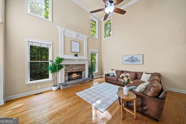 214 Davis Mill Rd, Ball Ground, GA 30107 - living room featuring ceiling fan, healthy amount of natural light, a fireplace, ornamental molding, and a towering ceiling