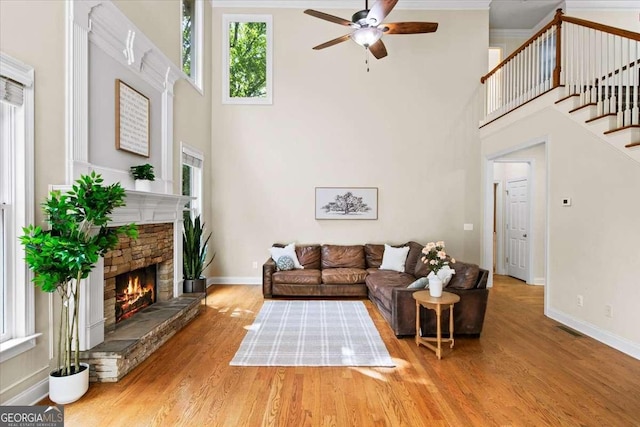 214 Davis Mill Rd, Ball Ground, GA 30107 - living area featuring a towering ceiling, a ceiling fan, a fireplace, wood finished floors, and stairs