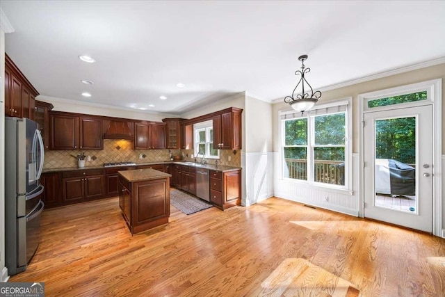 214 Davis Mill Rd, Ball Ground, GA 30107 - kitchen featuring appliances with stainless steel finishes, decorative backsplash, a kitchen island, light wood finished floors, and ornamental molding