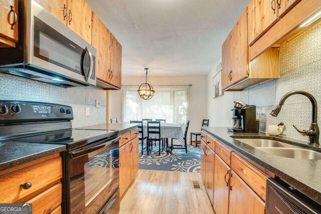 327 Brucken Strasse Unit 311, Helen, GA 30545 - kitchen featuring black range with electric stovetop, stainless steel microwave, decorative backsplash, and dark countertops
