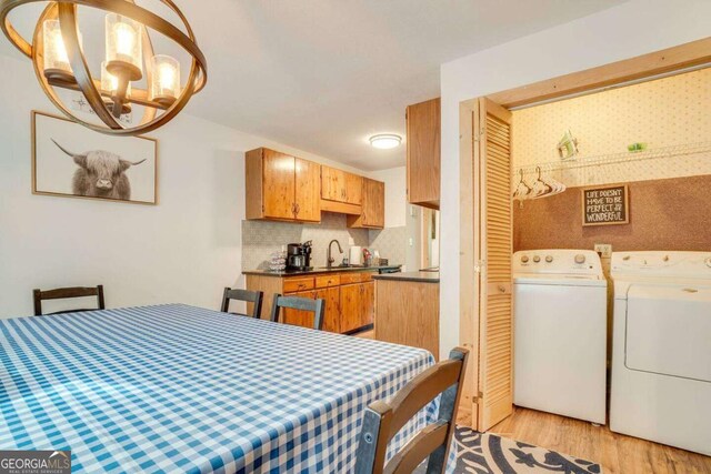 327 Brucken Strasse Unit 311, Helen, GA 30545 - dining area with washing machine and dryer, light wood-style floors, and a chandelier