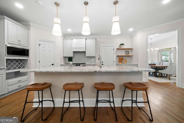 4544 Cavallon Way NW, Acworth, GA 30101 - kitchen featuring built in microwave, crown molding, decorative backsplash, white cabinets, and a kitchen bar