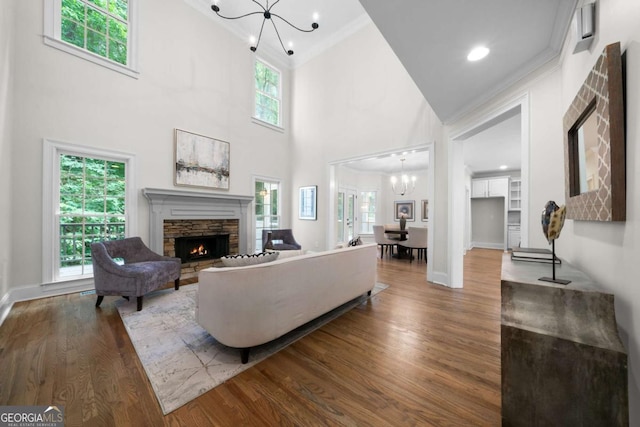 4544 Cavallon Way NW, Acworth, GA 30101 - living area featuring a chandelier, a stone fireplace, wood finished floors, plenty of natural light, and a high ceiling