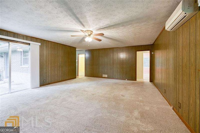 741 Greenhill Dr NE, Conyers, GA 30012 - unfurnished room featuring a wall unit AC, a ceiling fan, healthy amount of natural light, wood walls, and light carpet