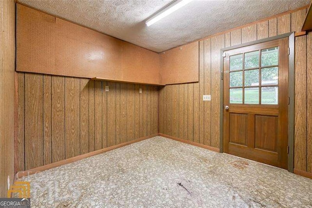 741 Greenhill Dr NE, Conyers, GA 30012 - doorway with carpet floors, a textured ceiling, and wood walls