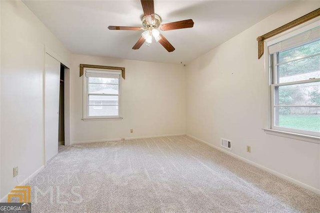 741 Greenhill Dr NE, Conyers, GA 30012 - unfurnished bedroom with light colored carpet, ceiling fan, and a closet