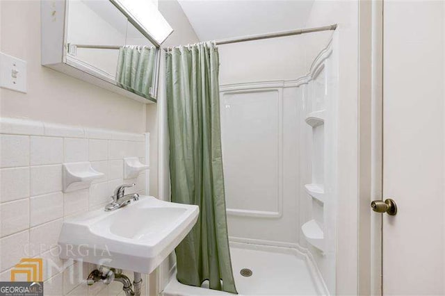 741 Greenhill Dr NE, Conyers, GA 30012 - bathroom featuring a shower stall, tile walls, and a skylight