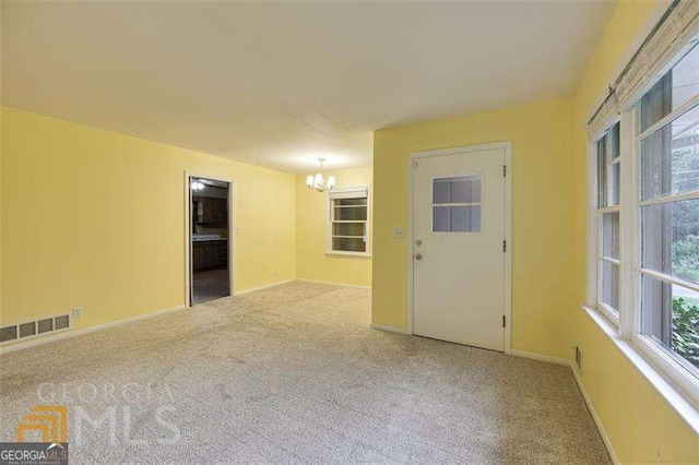 741 Greenhill Dr NE, Conyers, GA 30012 - carpeted empty room featuring a chandelier and healthy amount of natural light
