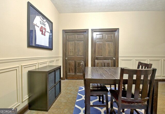 115 Shoal Creek Dr, Sharpsburg, GA 30277 - dining area featuring a decorative wall, a textured ceiling, and wainscoting