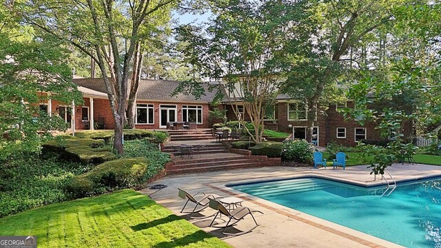 115 Shoal Creek Dr, Sharpsburg, GA 30277 - swimming pool featuring a yard and a patio