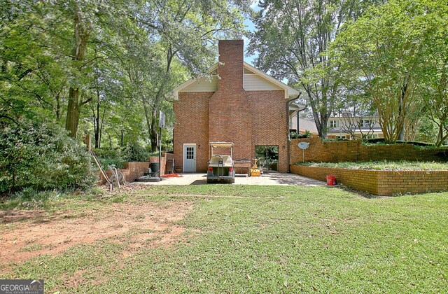 115 Shoal Creek Dr, Sharpsburg, GA 30277 - rear view of house with a patio area, a chimney, brick siding, and a yard