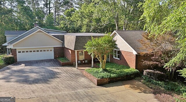115 Shoal Creek Dr, Sharpsburg, GA 30277 - view of front of home featuring brick siding, concrete driveway, a garage, and roof with shingles