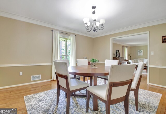 115 Shoal Creek Dr, Sharpsburg, GA 30277 - dining area featuring light wood-style floors, a chandelier, and ornamental molding