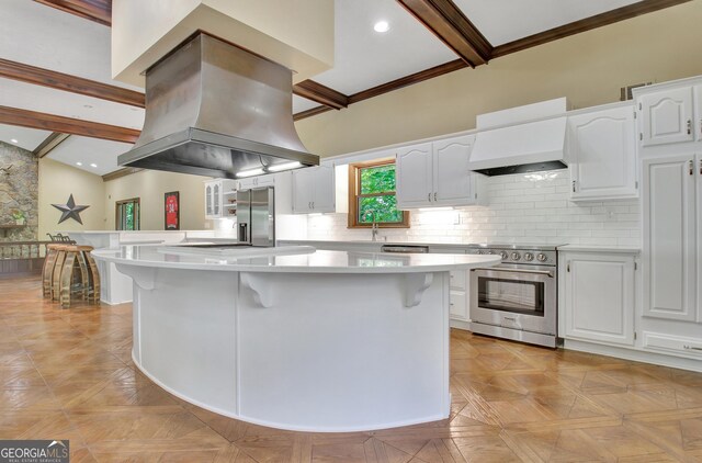 115 Shoal Creek Dr, Sharpsburg, GA 30277 - kitchen with island exhaust hood, appliances with stainless steel finishes, light countertops, a breakfast bar, and ornamental molding