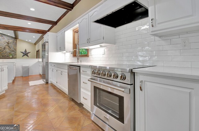 115 Shoal Creek Dr, Sharpsburg, GA 30277 - kitchen with appliances with stainless steel finishes, range hood, white cabinets, light countertops, and a wainscoted wall