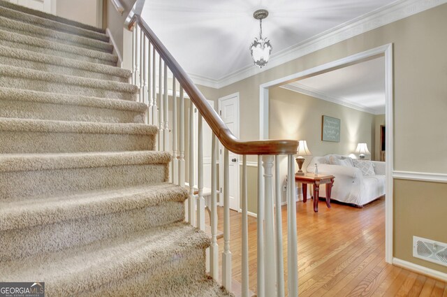 115 Shoal Creek Dr, Sharpsburg, GA 30277 - staircase featuring hardwood / wood-style flooring, ornamental molding, and a chandelier