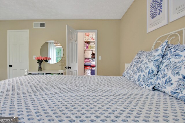 115 Shoal Creek Dr, Sharpsburg, GA 30277 - bedroom featuring a spacious closet, crown molding, a textured ceiling, and a closet