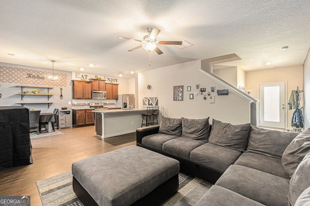 3350 Clawing Hawk Way, Douglasville, GA 30135 - living area with light wood-type flooring, a ceiling fan, a textured ceiling, and stairway