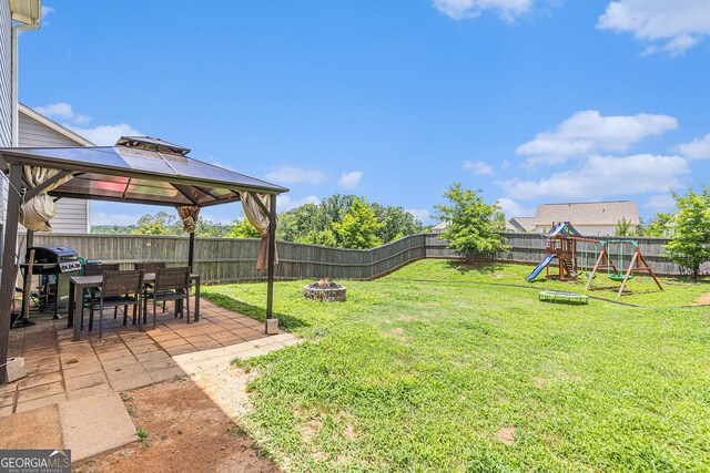 3350 Clawing Hawk Way, Douglasville, GA 30135 - fenced backyard with an outdoor fire pit, a patio area, a gazebo, and a playground