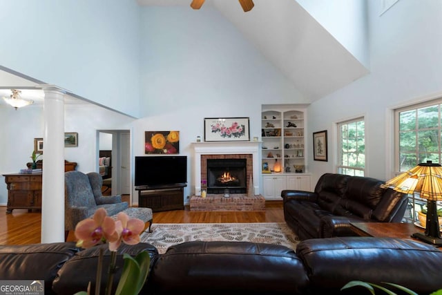 17 Shotgun Rd NW, Cartersville, GA 30121 - living room with high vaulted ceiling, wood finished floors, ceiling fan, a brick fireplace, and ornate columns