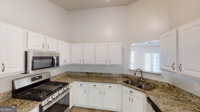 3157 Peartree Dr NW, Acworth, GA 30101 - kitchen featuring stainless steel appliances, white cabinets, light stone countertops, and a towering ceiling
