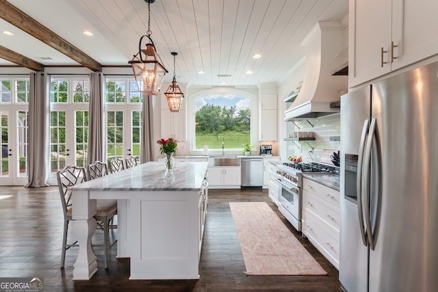 2816 Oconee Springs Dr, Statham, GA 30666 - kitchen with stainless steel appliances, white cabinets, a center island, a breakfast bar area, and light stone counters