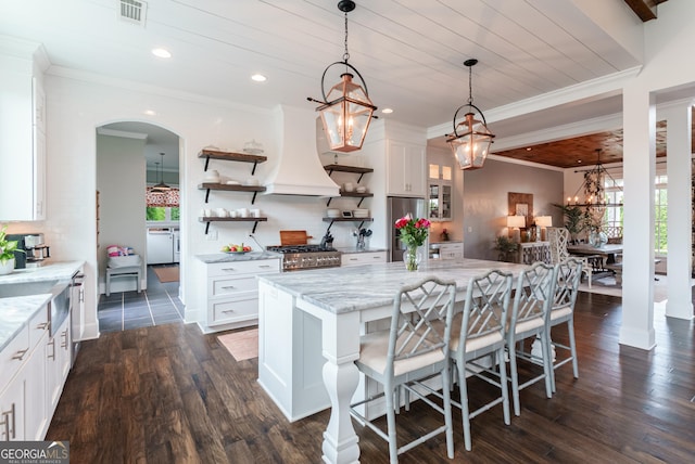 2816 Oconee Springs Dr, Statham, GA 30666 - kitchen with a chandelier, appliances with stainless steel finishes, premium range hood, white cabinetry, and arched walkways