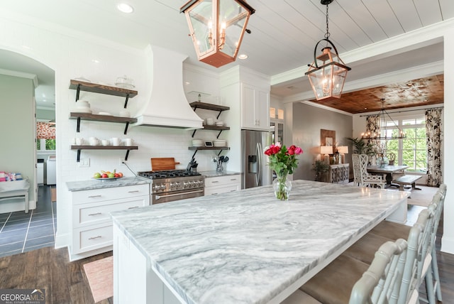 2816 Oconee Springs Dr, Statham, GA 30666 - kitchen featuring a chandelier, open shelves, appliances with stainless steel finishes, custom range hood, and crown molding