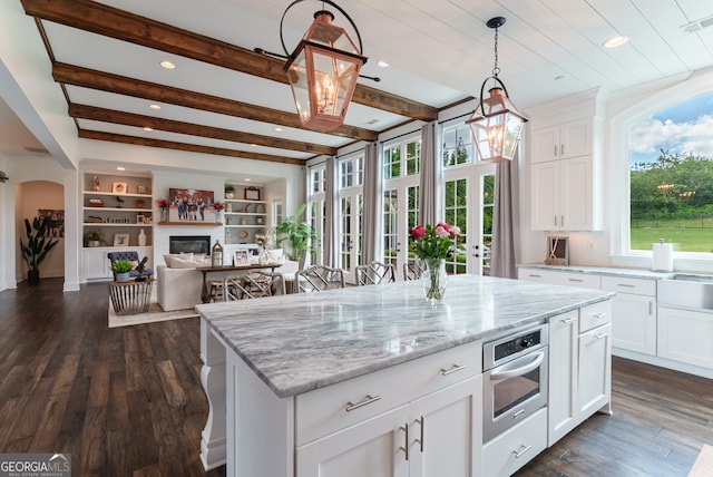 2816 Oconee Springs Dr, Statham, GA 30666 - kitchen featuring healthy amount of natural light, open floor plan, light stone countertops, white cabinetry, and recessed lighting