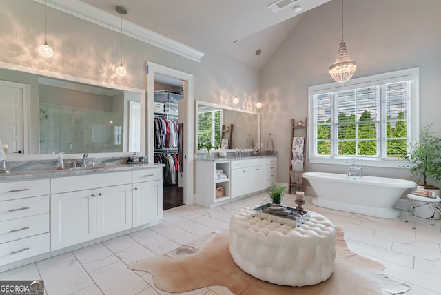 2816 Oconee Springs Dr, Statham, GA 30666 - bathroom with two vanities, a stall shower, a freestanding tub, vaulted ceiling, and marble finish flooring