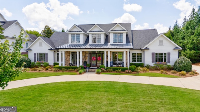 2816 Oconee Springs Dr, Statham, GA 30666 - view of front of property with a standing seam roof, a porch, a front lawn, and a metal roof