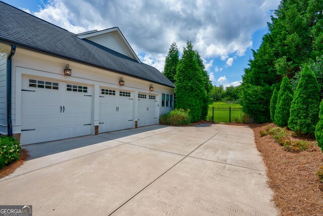 2816 Oconee Springs Dr, Statham, GA 30666 - view of side of home with concrete driveway and roof with shingles
