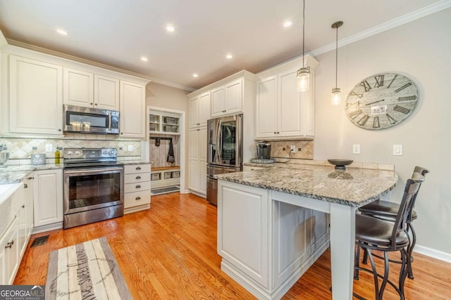 1461 Radstone Dr, Lawrenceville, GA 30044 - kitchen featuring stainless steel appliances, a peninsula, crown molding, backsplash, and a kitchen bar