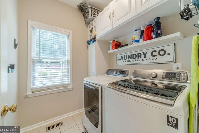1461 Radstone Dr, Lawrenceville, GA 30044 - laundry room with washer and dryer, plenty of natural light, cabinet space, and light tile patterned floors